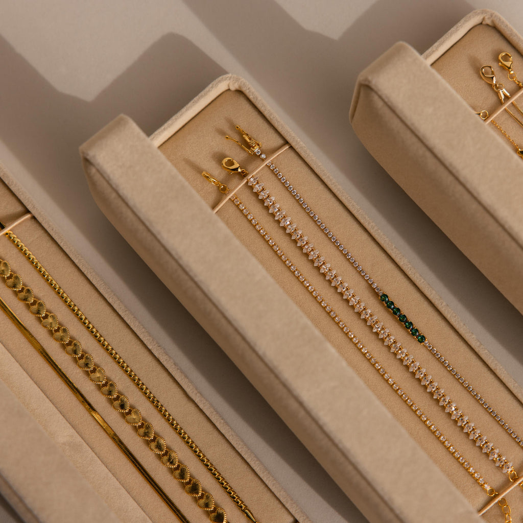 Gold and diamond bracelets and earrings organized in a velvet Bracelet Travel Case, showcased under soft lighting.
