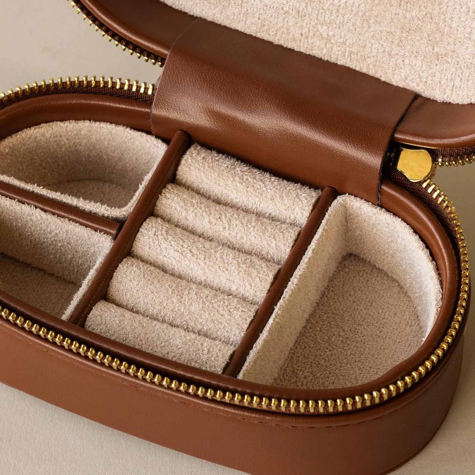 Corporate Gift Box: Elegant brown leather case with beige velvet interior, divided compartments, and gold zipper—perfect for organizing jewelry or as a premium jewelry gift box.