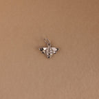 The Honeybee Charm in Sterling Silver, ideal for nature jewelry lovers, is shown on a simple light brown background.