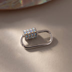 The Opal Carabiner Clasp in White Gold features a decorative, opal-studded cylinder and is perfect as a charm connector for your favorite opal jewelry.