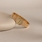 Our Luxe Square Timepiece watch in 18K Gold on a beige background