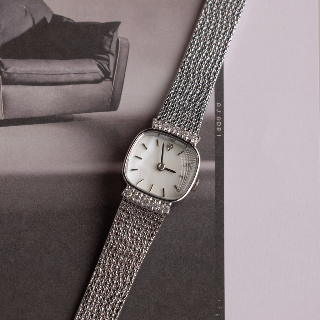 Close up of our Luxe Square Timepiece watch in Sterling Silver, laid on a black and white photo