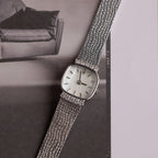 Close up of our Luxe Square Timepiece watch in Sterling Silver, laid on a black and white photo