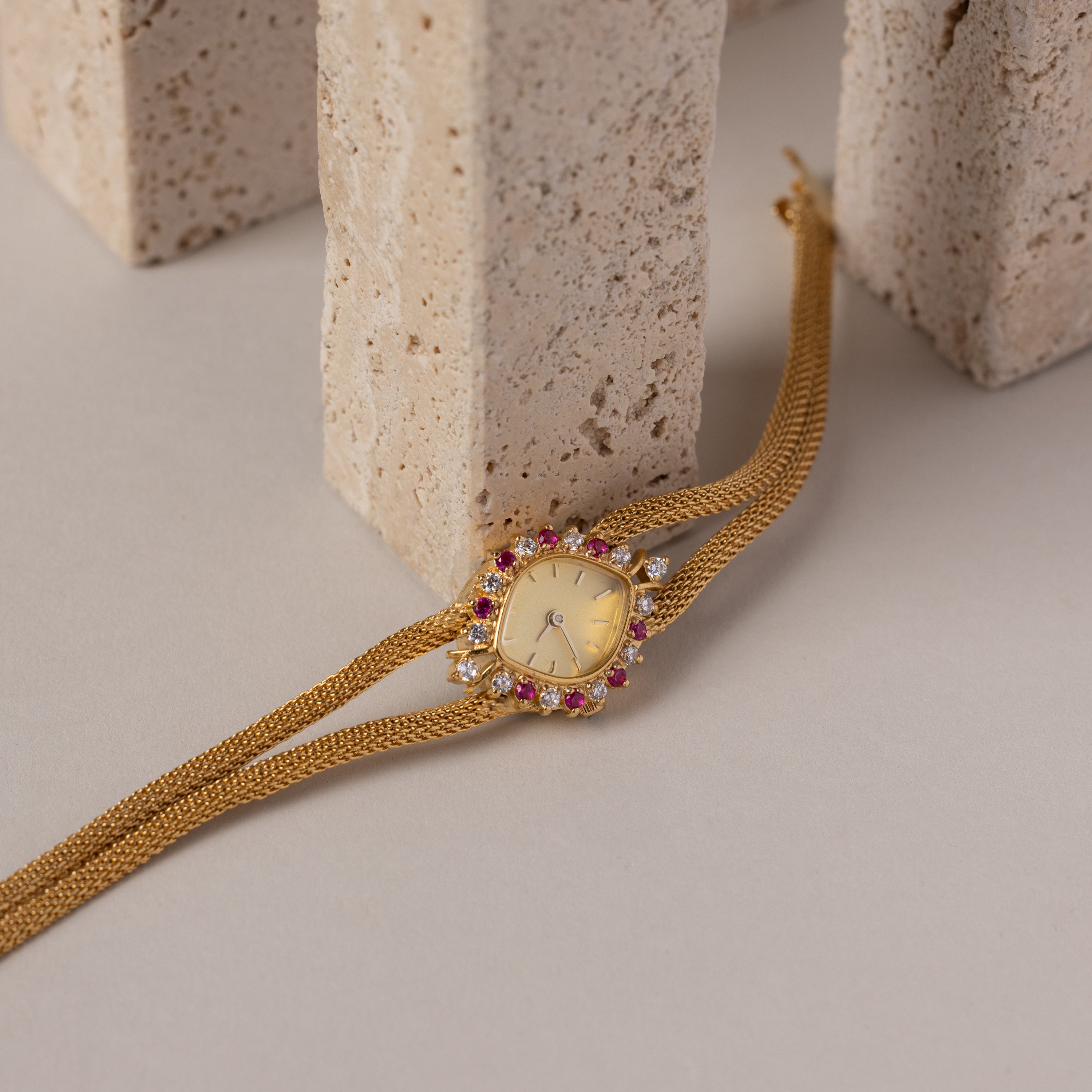 Our Duo Chain Ruby Timepiece watch on a neutral background