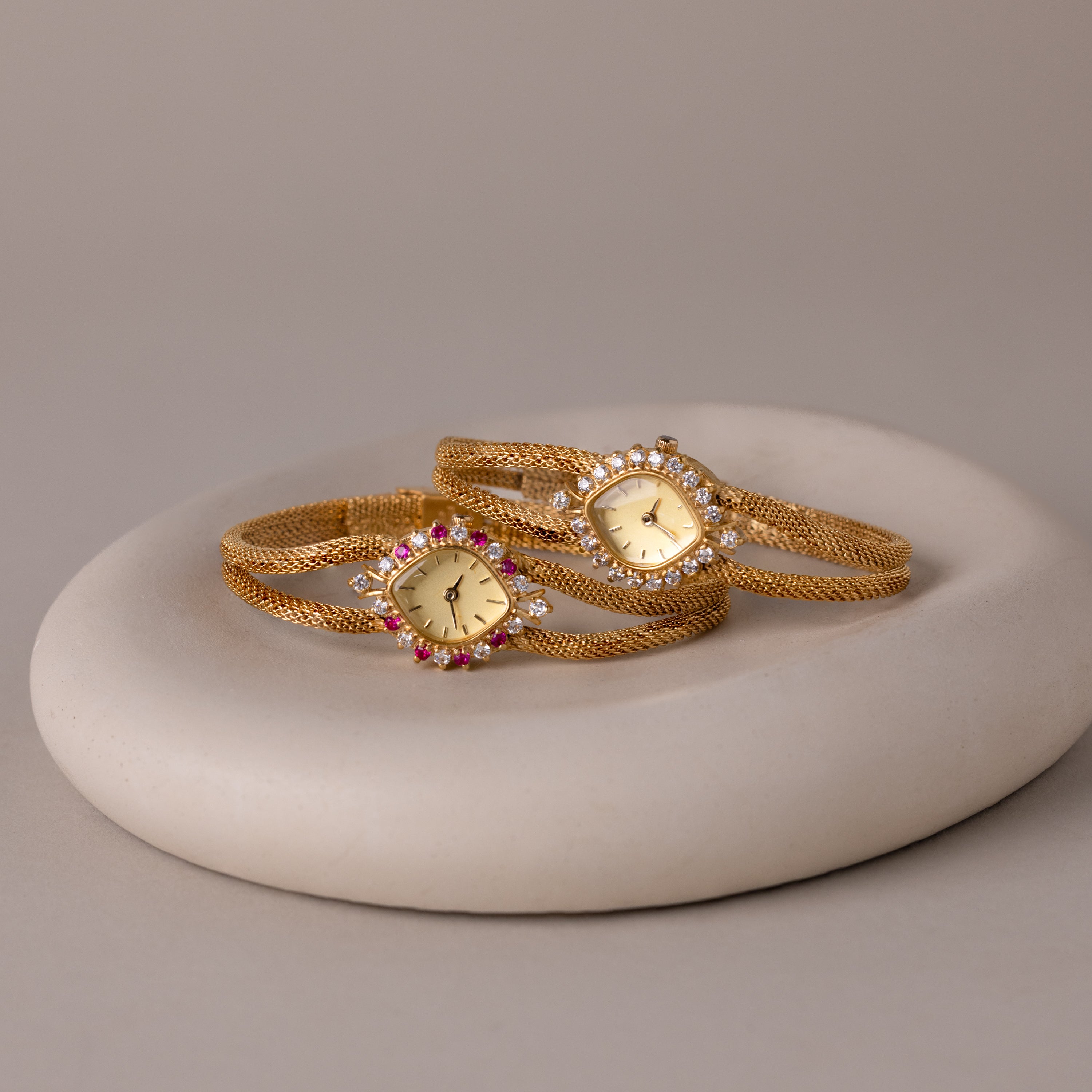 Image of both of our Duo Chain Gemstone Timepiece in diamond and ruby, laid together in a jewelry dish