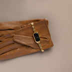 Brown leather glove with our Midnight Link Timepiece watch on a beige background