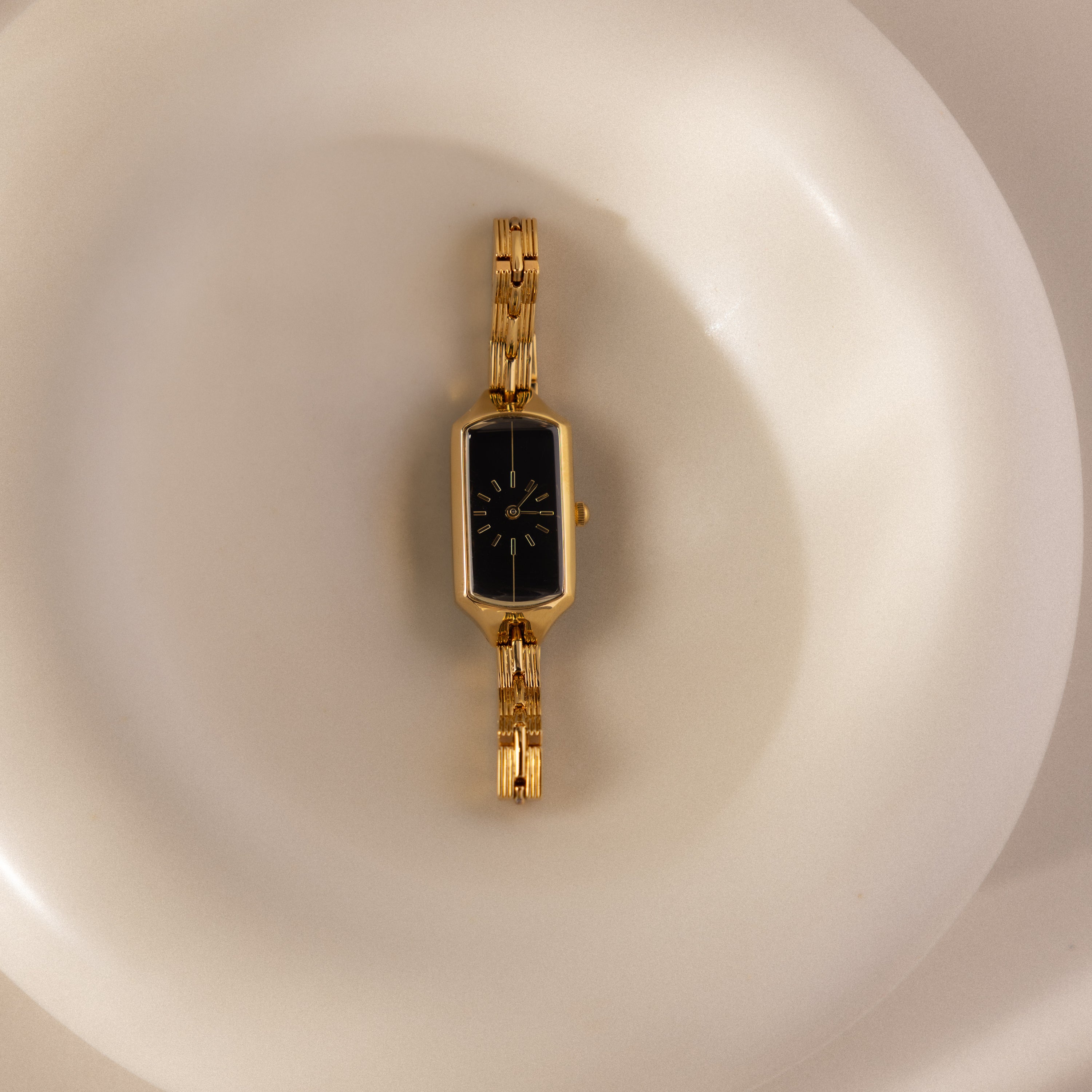 Our Midnight Link Timepiece watch on a ceramic dish