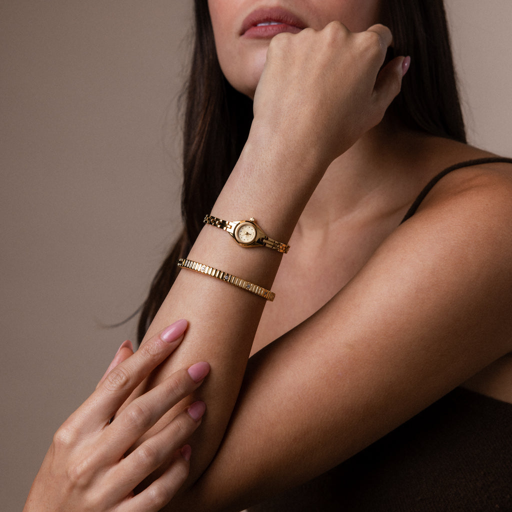 A model wearing our Petite Round Timepiece watch with our Ribbed Diamond Cuff Bracelet