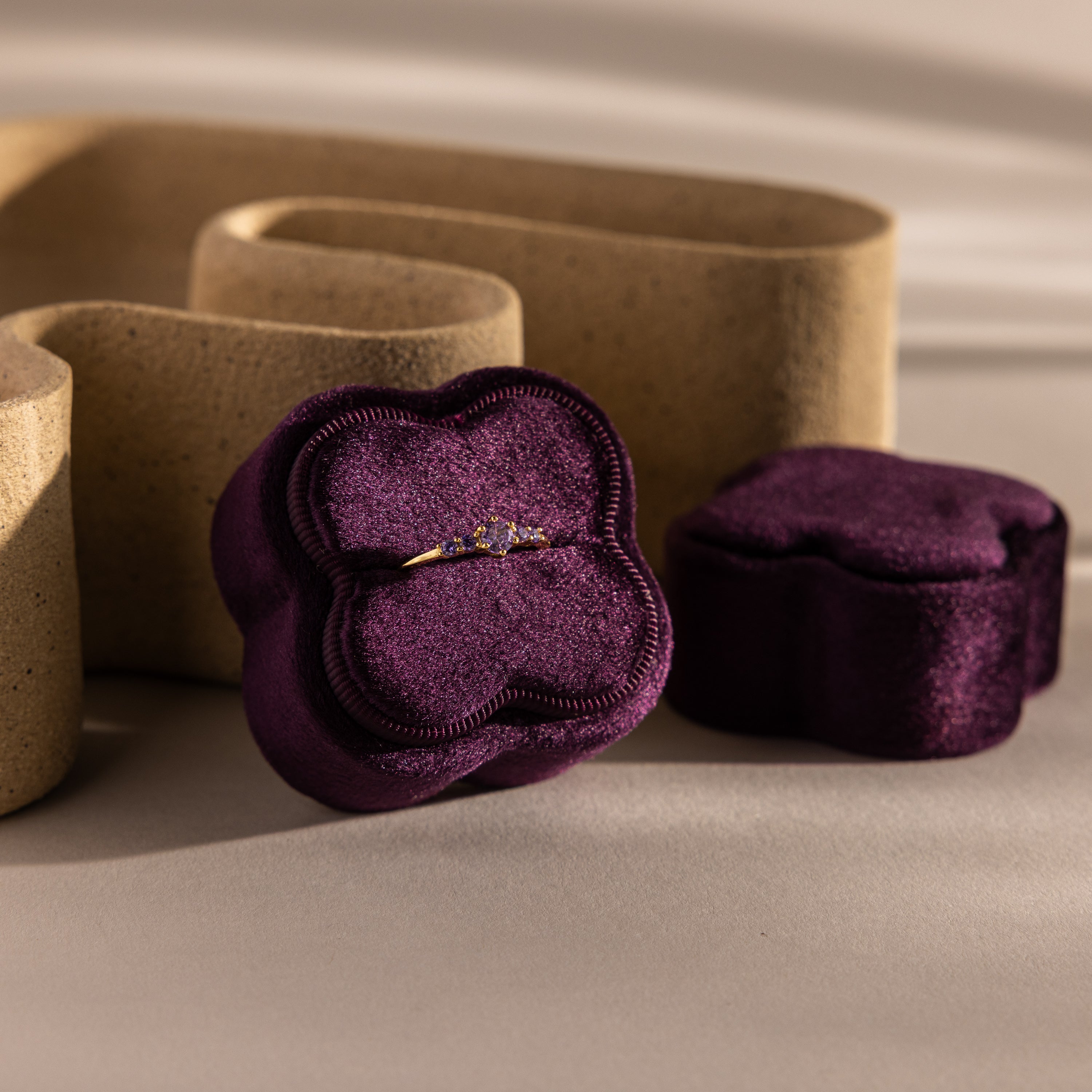 Gold ring with small diamonds in the Purple Flower Velvet Ring Box, featuring a matching purple lid and neutral background decor.