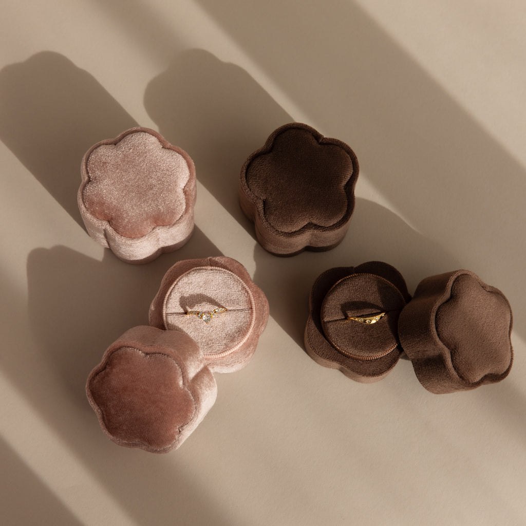 Two Flower Velvet Ring Boxes, one pink and one brown, each display a gold ring on a beige surface—making this set the ideal proposal accessory.