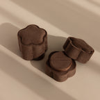 Three Brown Flower Velvet Ring Boxes sit on a beige surface with soft shadows—perfect for treasuring your special proposal moments. Try the Brown Flower Velvet Ring Box for an elegant touch.