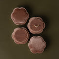 Four Pink Flower Velvet Ring Boxes, one open to reveal a delicate diamond ring, arranged on an olive background.