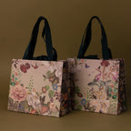 The Gift Wrap Add-On features two floral-patterned gift bags with dark handles, offering an elegant wrapping solution, shown on a plain olive-green background.