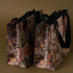 The Floral Gift Bag Add-On features two elegant floral-patterned bags with black handles, perfect for adding a special finishing touch to any present.