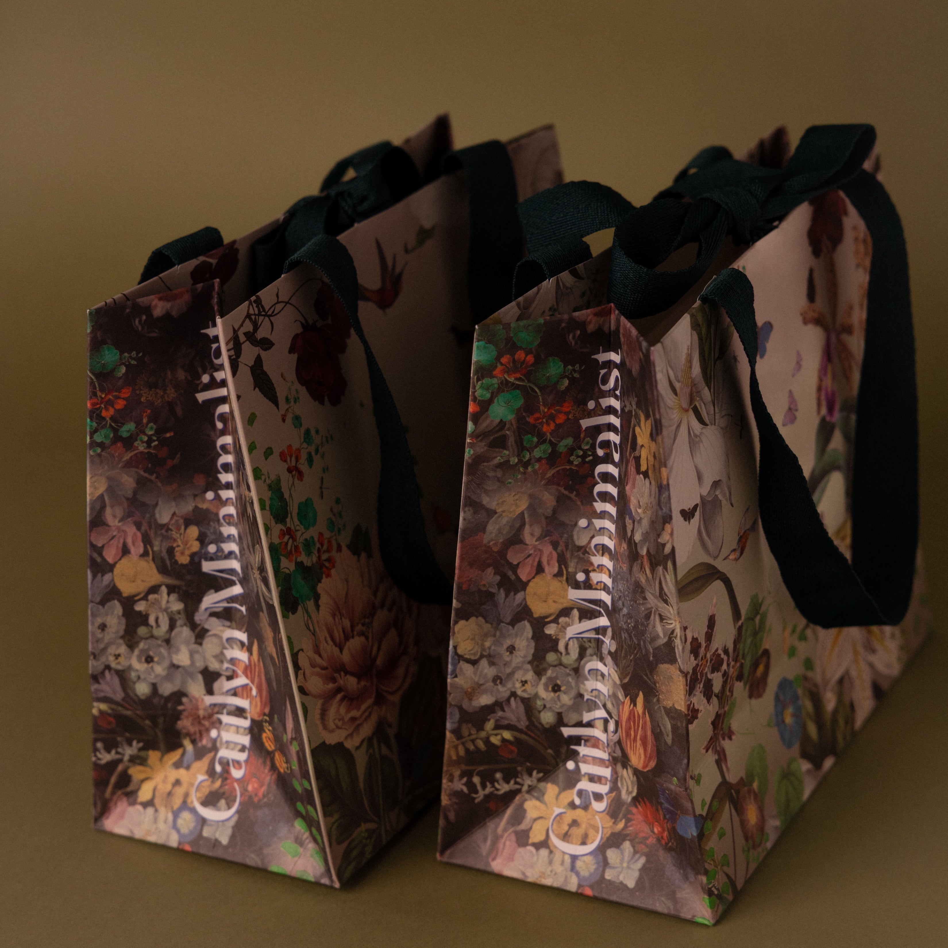 The Floral Gift Bag Add-On features two elegant floral-patterned bags with black handles, perfect for adding a special finishing touch to any present.