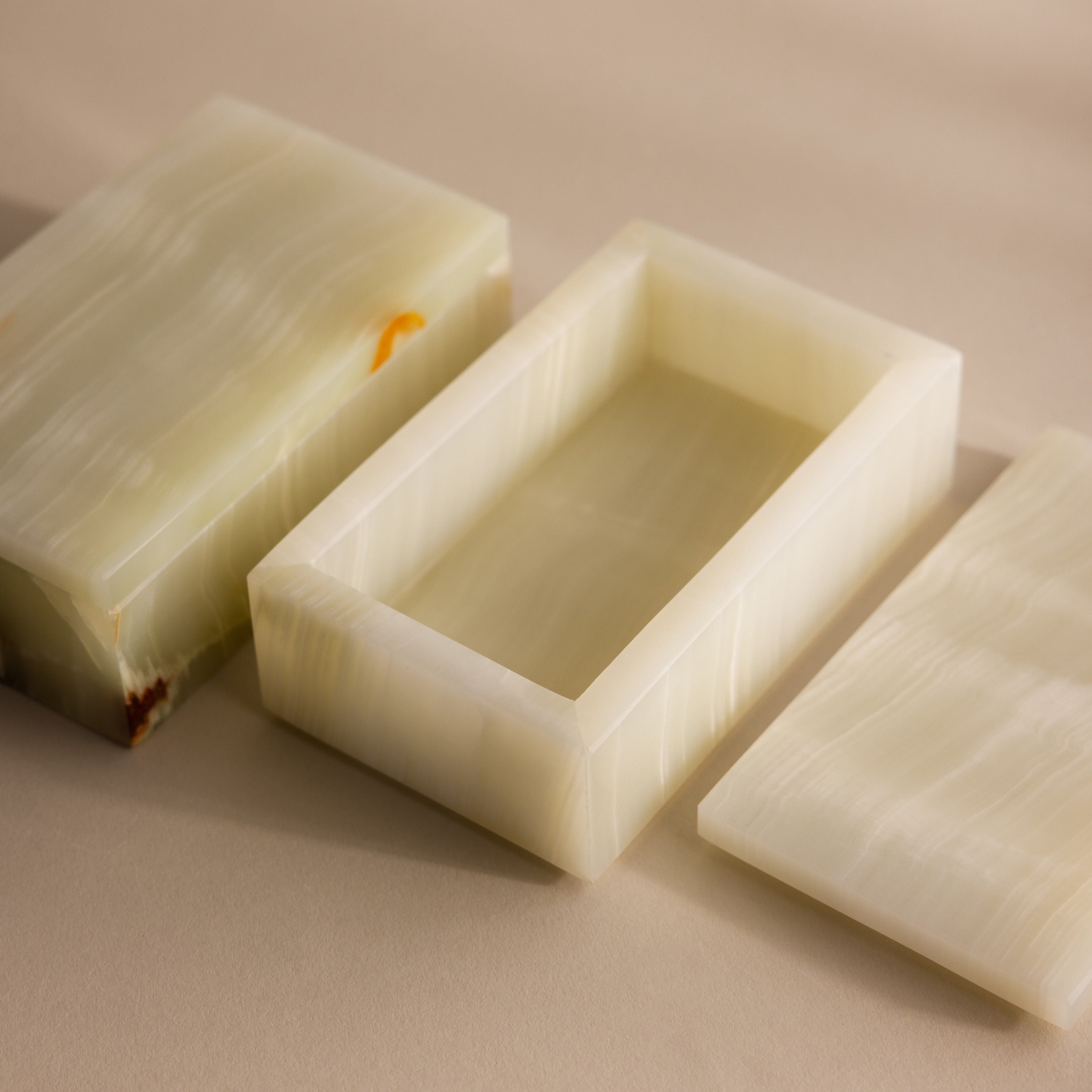 Green Onyx Jewelry Box with lid removed, showcasing its smooth, creamy light green marble texture on a beige surface.