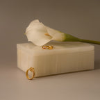 A white calla lily, gold rings, and a gold earring rest on a handcrafted Green Onyx Jewelry Box, set against a neutral background.