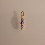 Ombre Lace Alexandrite Charm pendant featuring five small purple gemstones arranged vertically on a neutral background.