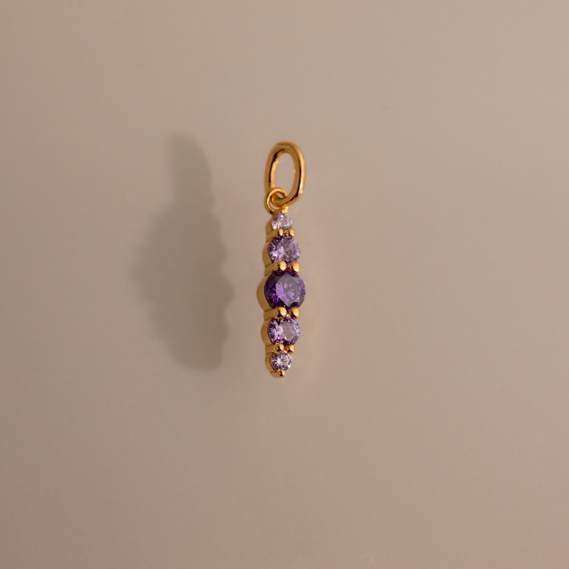 Ombre Lace Alexandrite Charm pendant featuring five small purple gemstones arranged vertically on a neutral background.