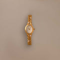 Chevron Diamond Link Timepiece featuring a gold-tone braided band and round face, shown against a plain beige background.