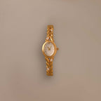 Chevron Diamond Link Timepiece featuring a gold-tone braided band and round face, shown against a plain beige background.