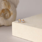 Butterfly Aquamarine Flatback Studs with sparkling stones displayed on a cream-colored surface, seashell in the background—a perfect personalized gift.