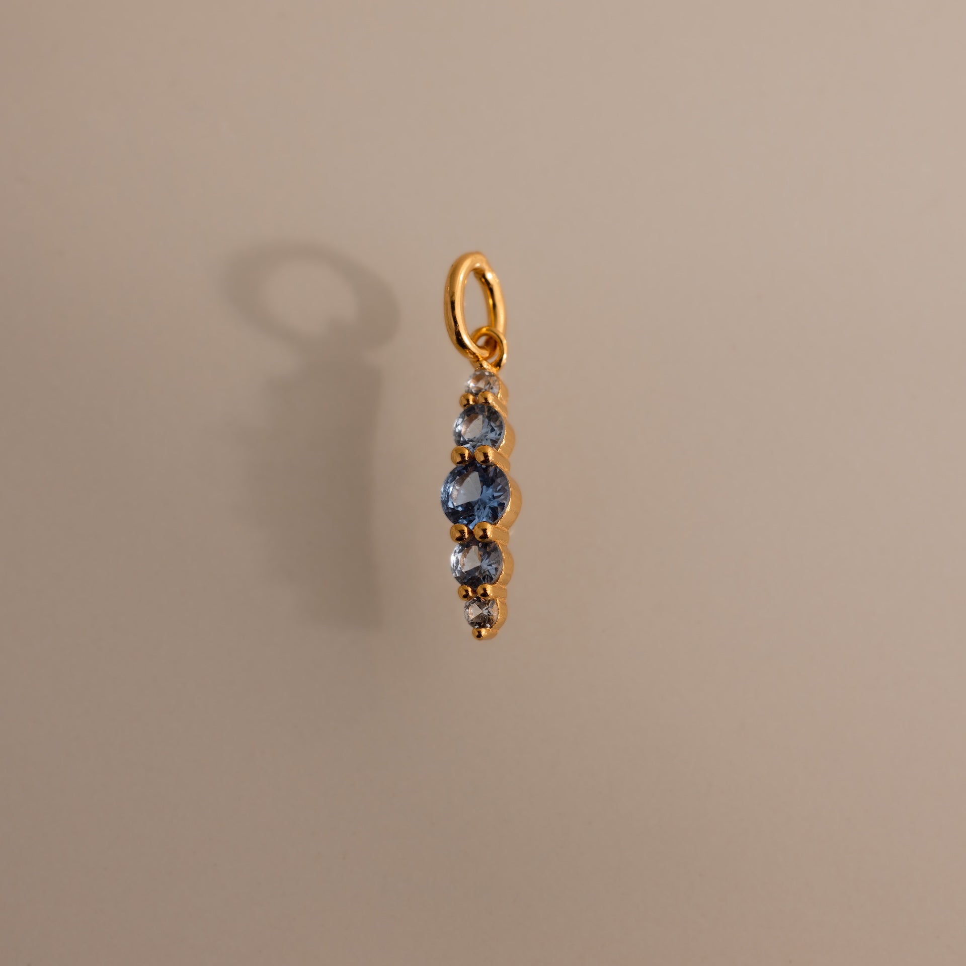 Ombre Lace Aquamarine Charm pendant featuring four blue gemstones in a vertical line on a light beige background—an elegant personalized birth month gift.