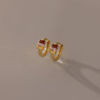 Multiple Baguette Birthstone Huggies in 18K Gold shown on a neutral background, perfect for adding a pop of colorful elegance to any outfit.