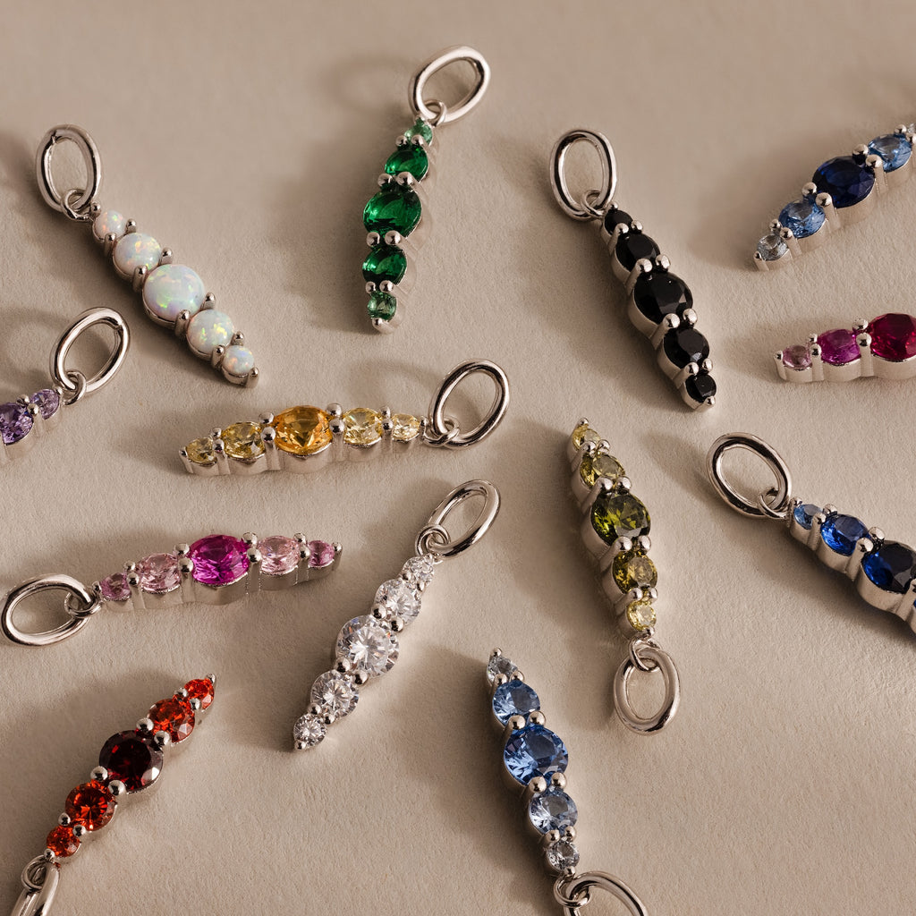 Ombre Lace Ruby Charm pendant shown with other gemstone and crystal charms, arranged in a circle on a neutral background.