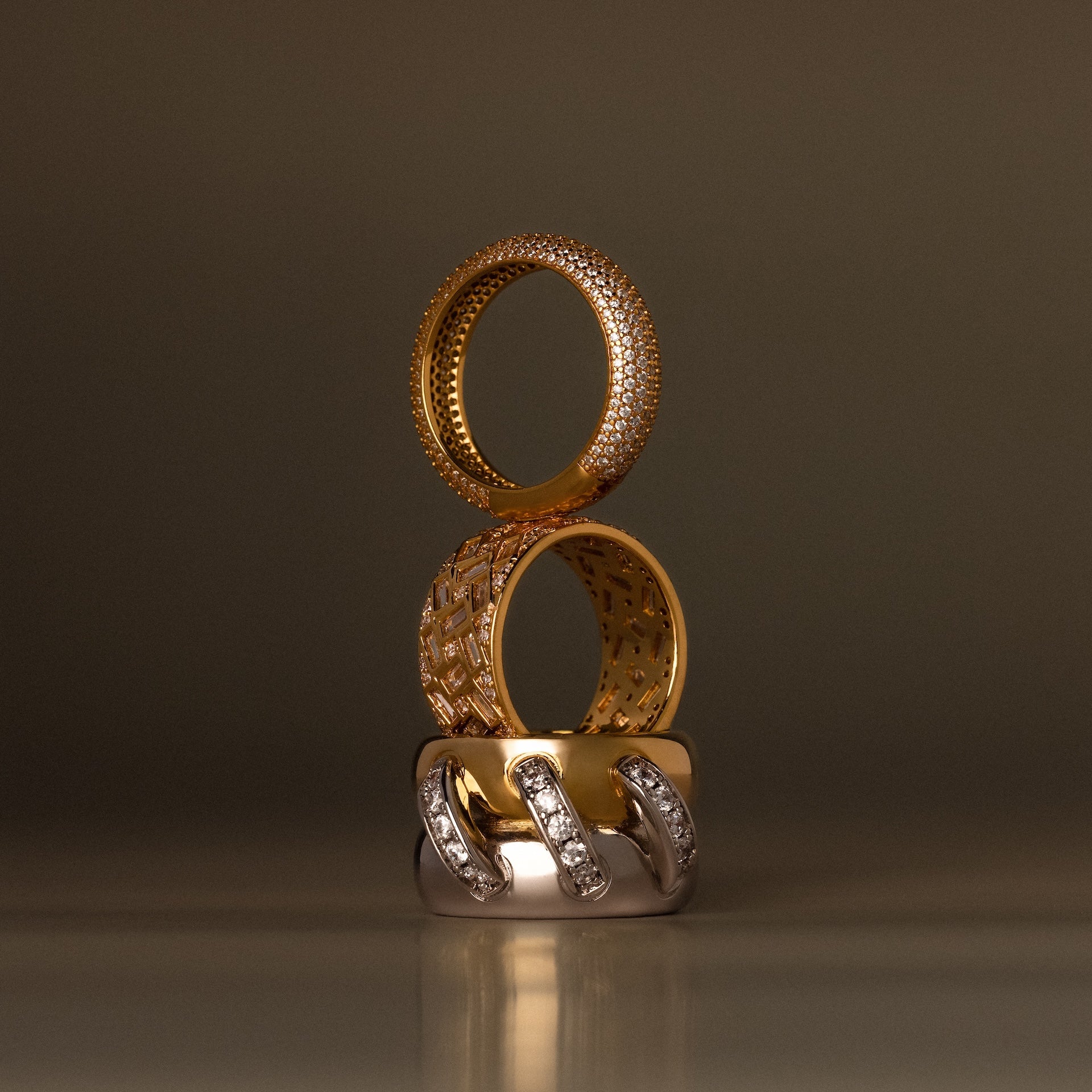 The Bold Pave Stacking Ring features elegant gold and silver tones with diamond accents, stacked vertically—perfect as an anniversary ring or wedding band.