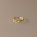 The Dainty Ribbed Opal Ring features a slim gold ribbed band with a small central opal, ideal as a delicate birthstone ring or for stacking, shown on a neutral background.