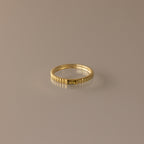 The Dainty Ribbed Peridot Ring features a gold, ribbed design and a minimalist look, displayed on a neutral background—perfect for stacking and adding elegant style to any outfit.