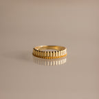 The Ribbed Topaz Stack Ring features a sculpted ribbed texture with small beads, ideal for a chic ring stack. Shown on a reflective, neutral surface.