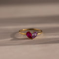 The Toi et Moi Teardrop Heart Ring in 18K Gold features two heart-shaped pink and purple gemstones set side by side in a romantic design.