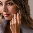 A woman with wavy hair smiles softly, showcasing the Toi et Moi Teardrop Heart Ring in Rose Gold on her finger.
