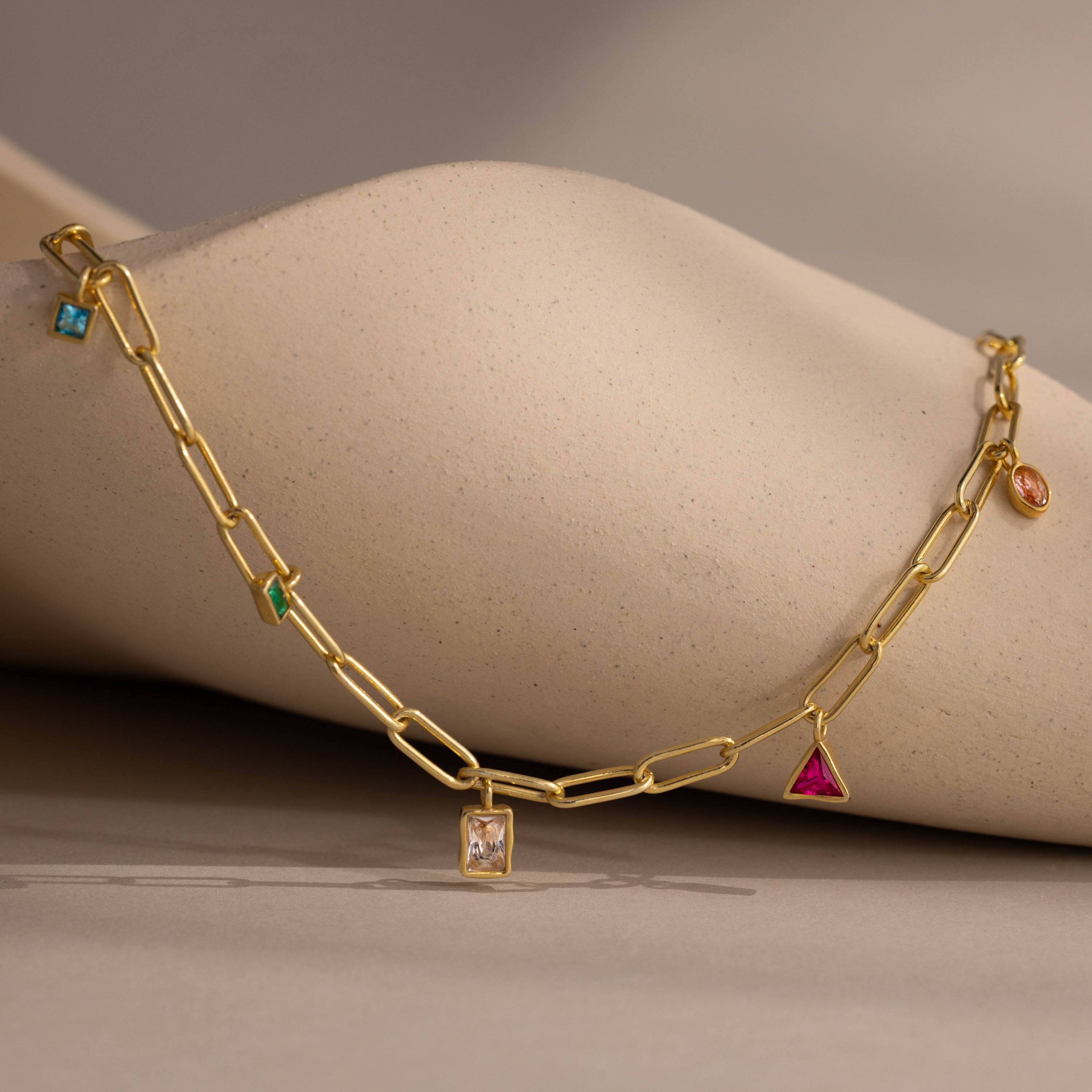 The Mixed Birthstone Charm Necklace features unique charms with colorful gemstones, making it the perfect personalized jewelry piece for charm necklace lovers.