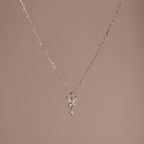 Butterfly Drop Necklace in Sterling Silver features a delicate butterfly pendant, ideal for nature-inspired jewelry lovers, and is shown on a plain beige background.