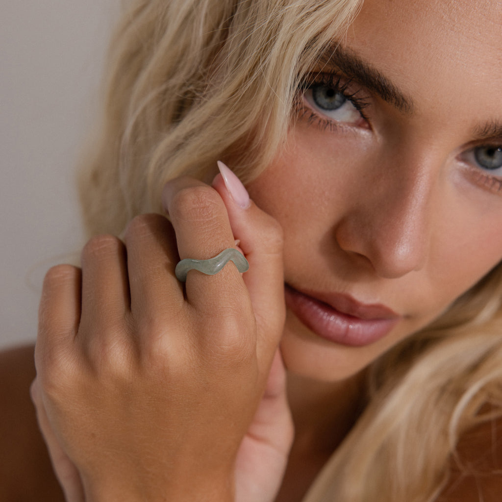 Model wearing the Jade Wave Ring featuring a curved silhouette carved from natural green jade.