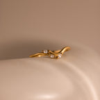 Gold curve marquise diamond ring featuring three marquise cut diamonds displayed on a smooth neutral surface.