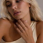 Model wearing a delicate gold curve marquise diamond ring with three marquise-cut diamonds.