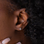 Close up of dainty silver Pave CZ Diamond North Star Stud Earring delicately worn on model's ear