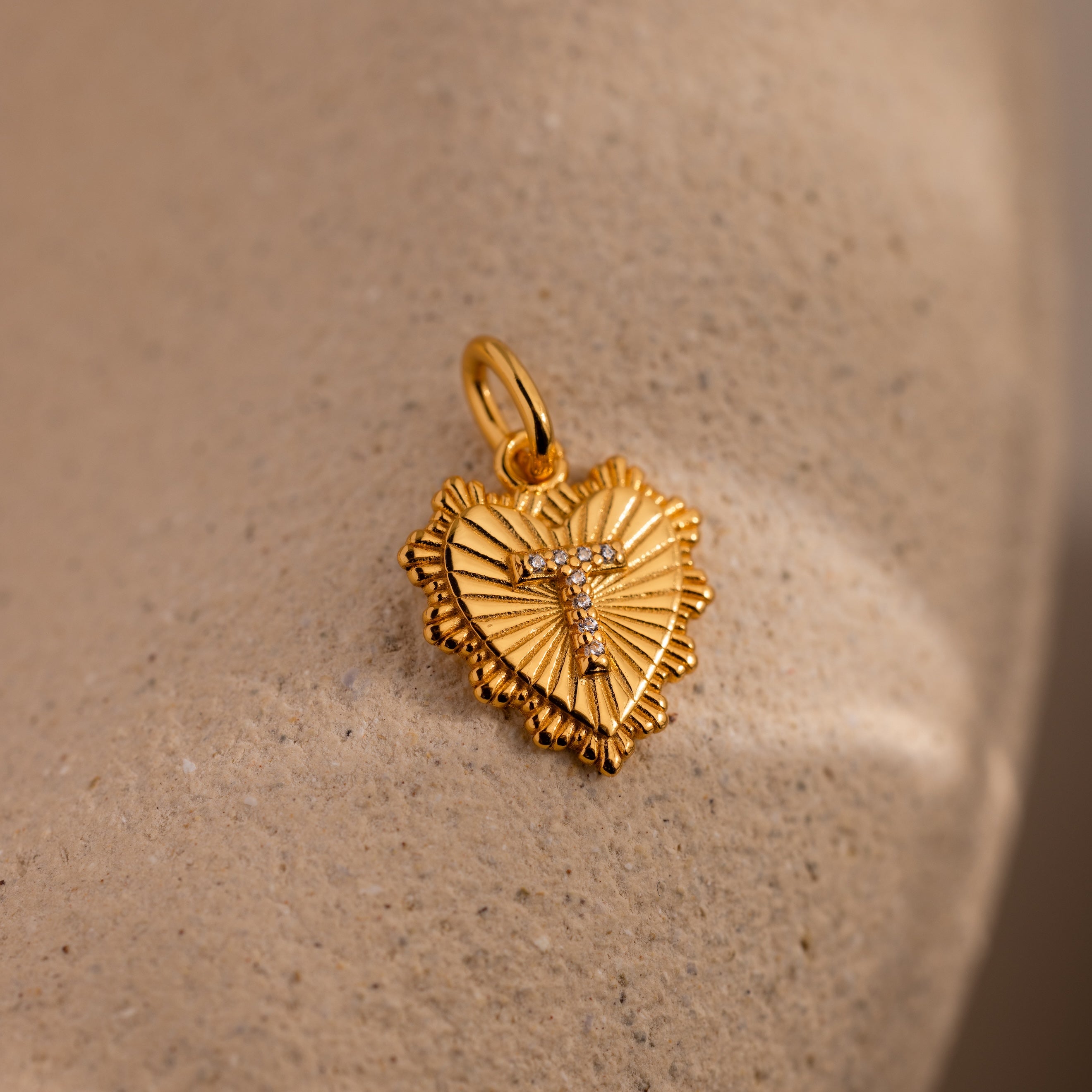 The Ribbed Heart Pave Initial Charm features a textured heart design with a crystal-set initial "T," making it an ideal piece for personalized jewelry.
