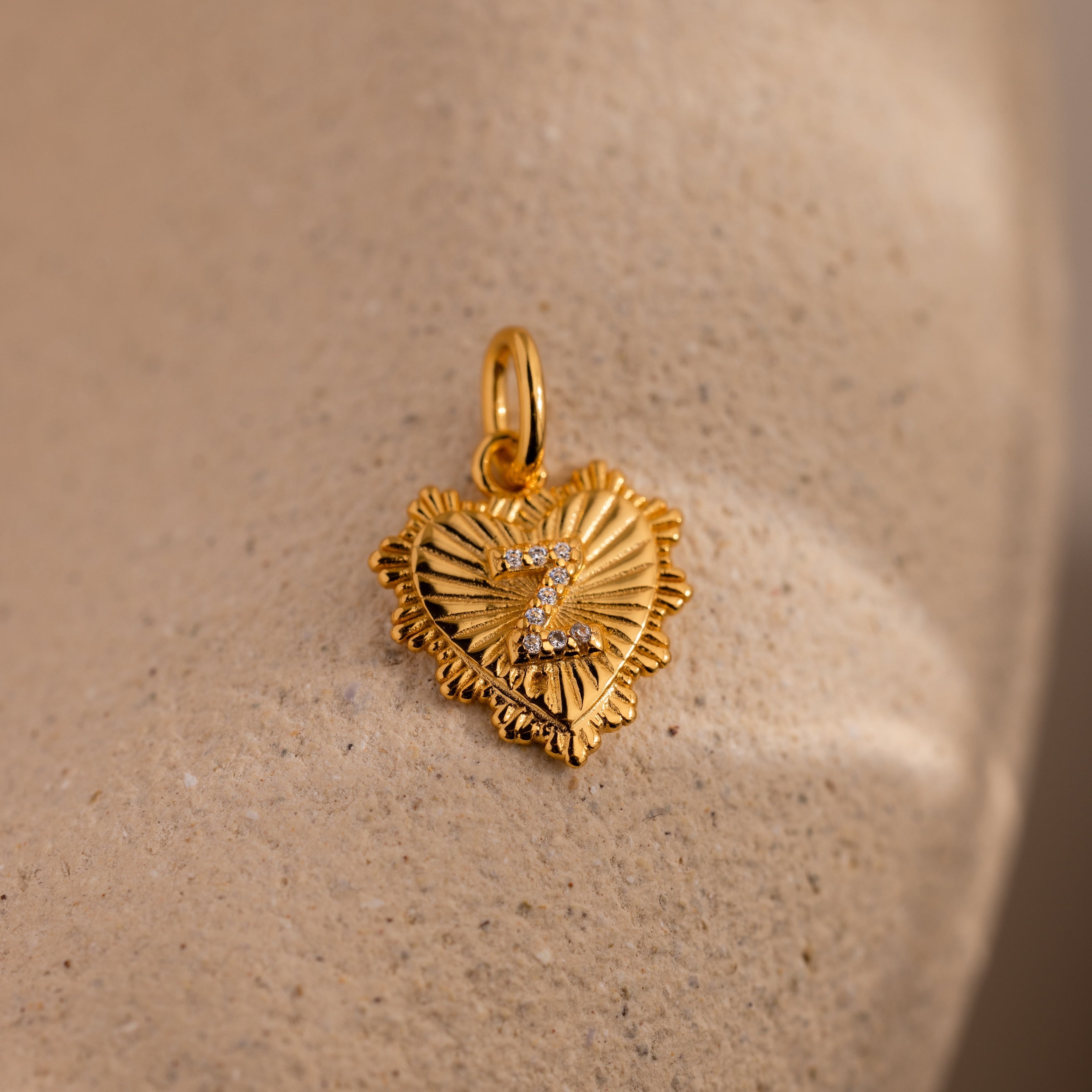 The Ribbed Heart Pave Initial Charm features a textured, ribbed gold heart with a number 7 pave-set with small diamonds—ideal for fans of personalized jewelry.