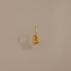 The Bubble Letter Charm in 18K Gold, shaped like a "B," is displayed on a beige background—ideal as personalized jewelry or a chic addition to your charm bracelet collection.