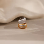 The Bold Pave Dome Charm in Silver, showcased on a soft beige surface, brings a timeless elegance to any jewelry collection.