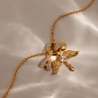 The Bold Pave Dome Charm features a gold necklace with diamond-studded letter A, ring, and angel wings with heart charms—ideal for expressing love and style in one elegant piece.