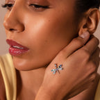 Close-up of a woman touching her face, wearing the Abalone Dragonfly Charm in Silver, featuring an iridescent wing that adds a delicate, nature-inspired accent to her look.