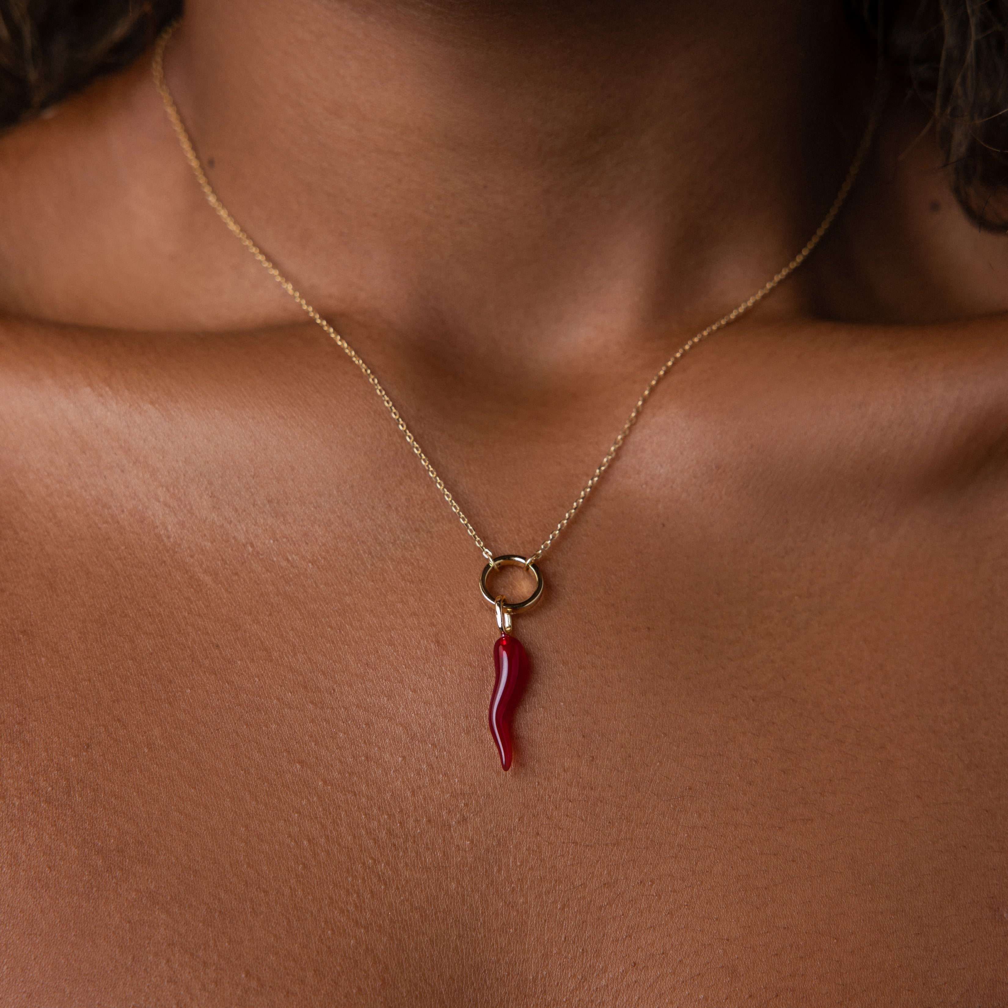 The Chili Pepper Charm necklace rests elegantly on the wearer’s neck and chest, adding a playful accent to any jewelry collection.