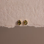 Rhombus Peridot Flatback Studs with gold settings shown on a textured off-white surface—ideal for adding a pop of modern green glamour.
