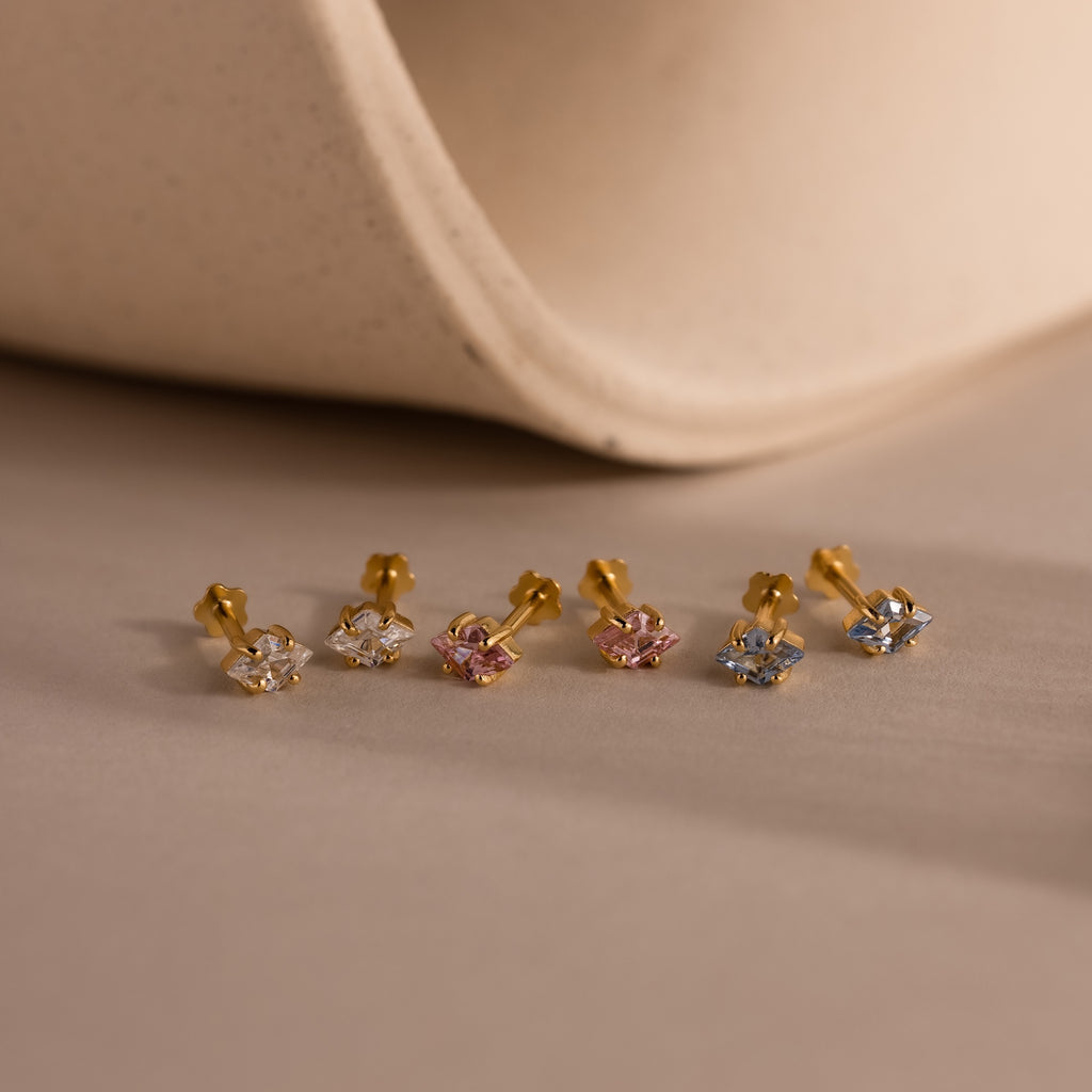 Six gold Rhombus Birthstone Flatback Studs with white, pink, and blue stones shown on a neutral background—ideal for those who love understated chic and modern glamour jewelry styles.